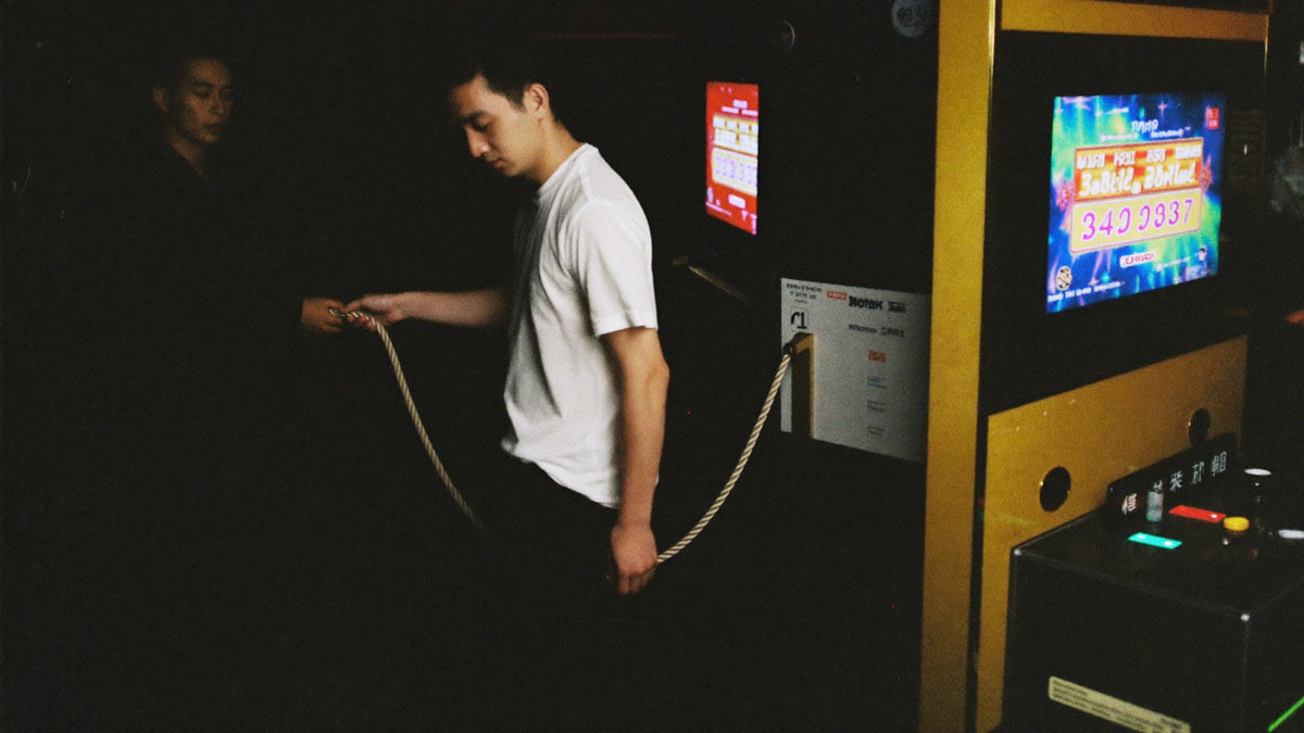 A host unhooking a velvet rope at the entrance to a high limit slot room as a well dressed player steps through